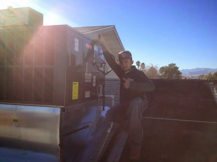 HVAC technician performing Air Duct Repair on a rooftop unit in Bellevue